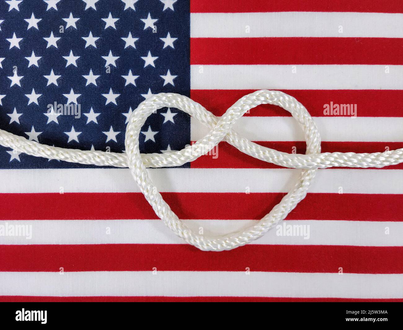 White rope heart on an American flag Stock Photo