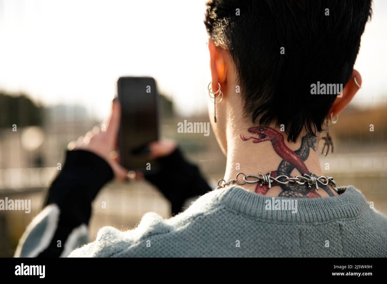 Unrecognizable girl with a tattoo taking a picture Stock Photo