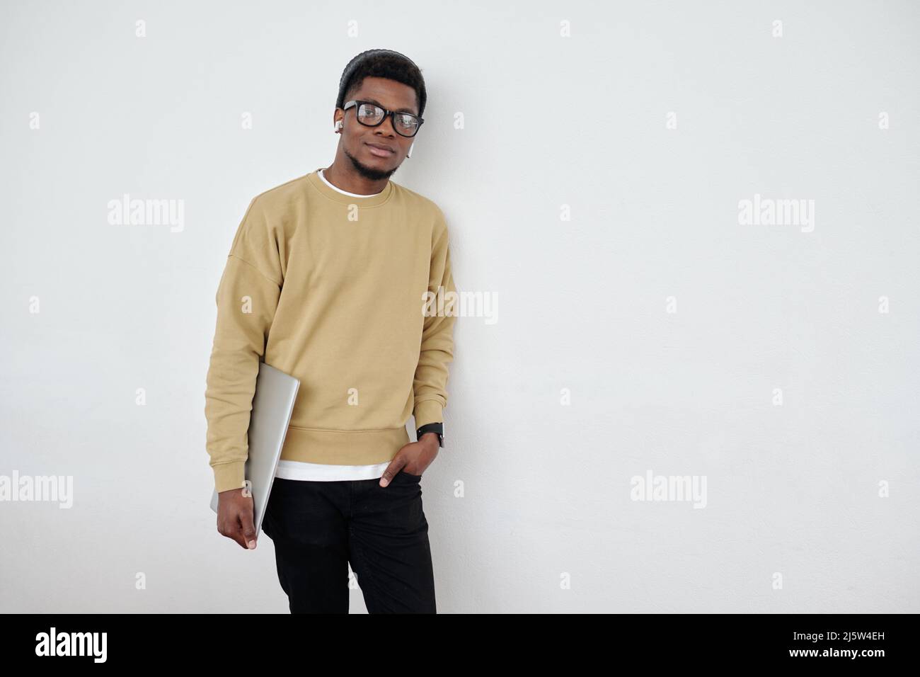 Young black man standing wall hi-res stock photography and images - Alamy