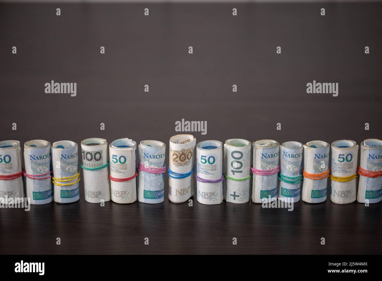 Banknotes rolled and tied together with a rubber band placed on a table