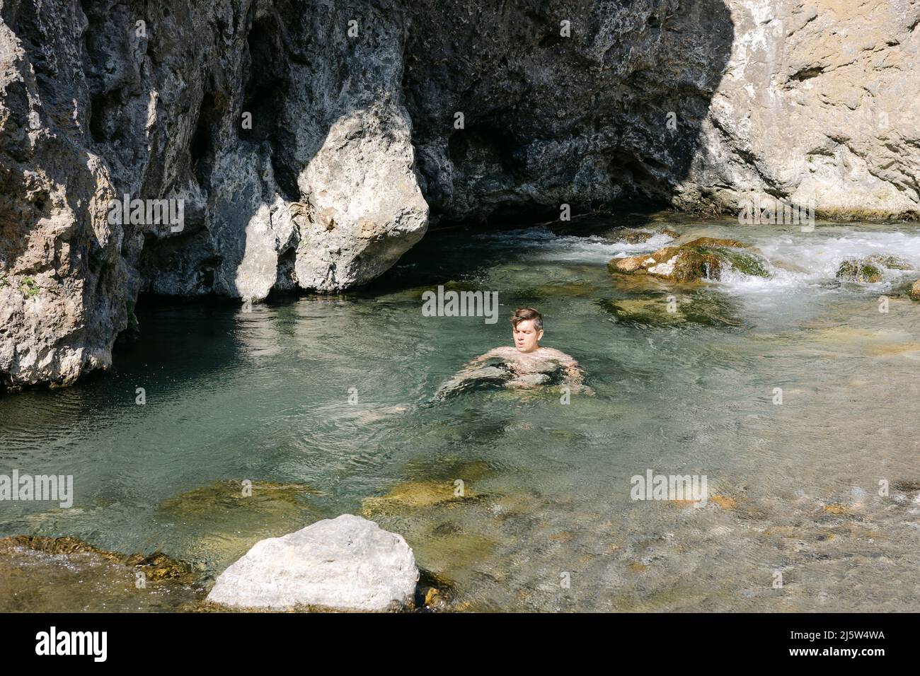 man sitting in river, Kourtaliotis Gorge,  Rethymno, Crete, greece Stock Photo