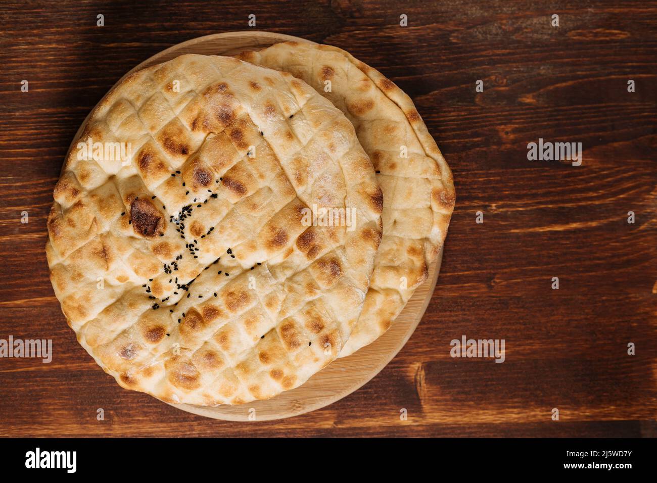 Top view of traditional Turkey or Bosnian pita bread called Somun or Lepina. Popular bread to eat during the month of Ramadan or Eid Mubarak. Rustic w Stock Photo