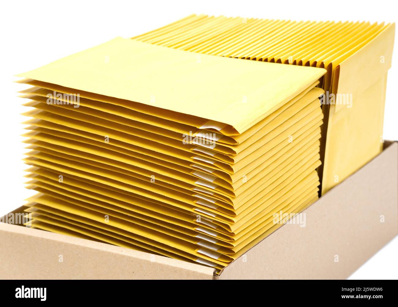 Two stacks of yellow envelopes in a kraft cardboard box isolated on white.  Office supplies Stock Photo - Alamy