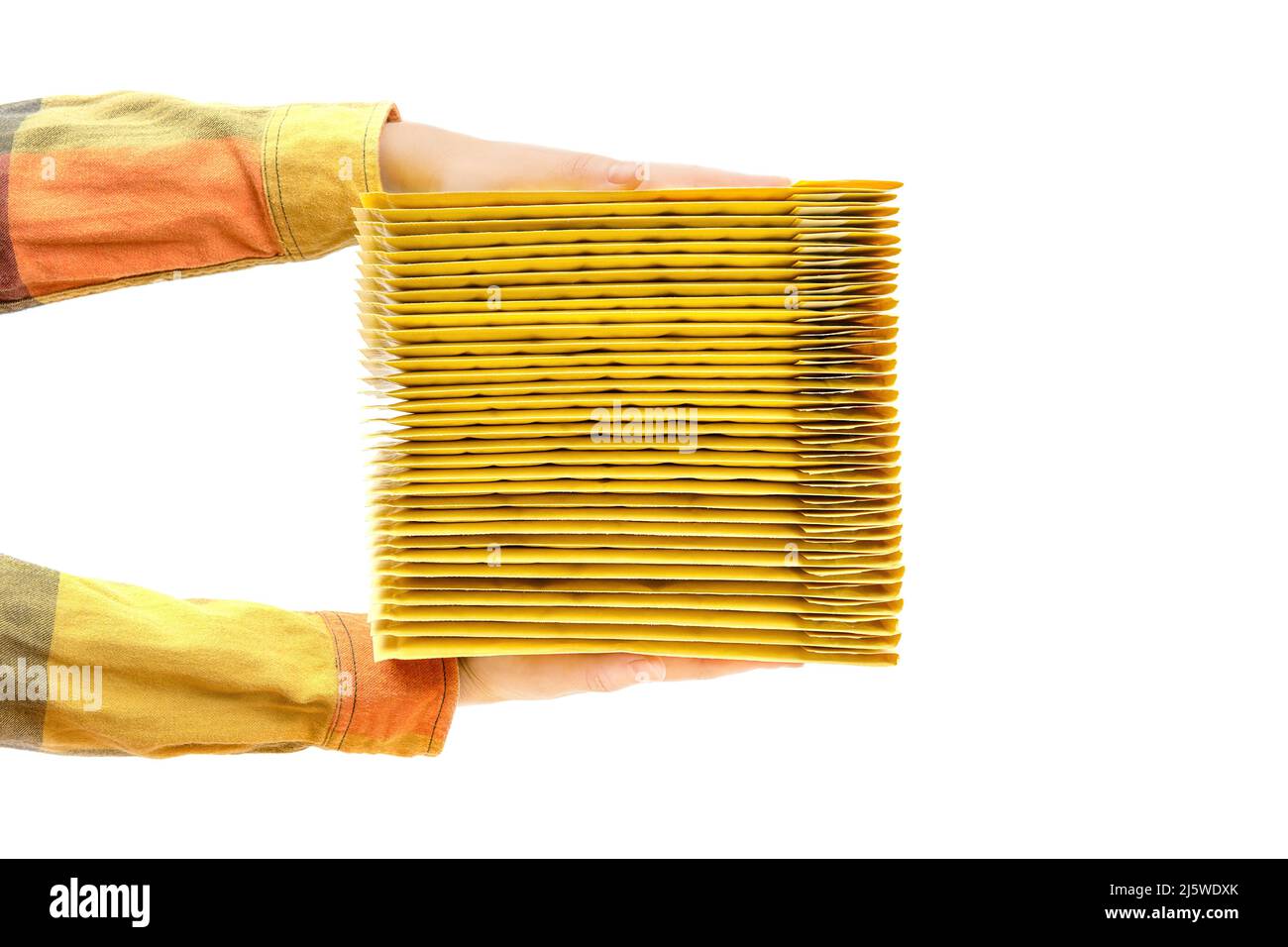 Hands holding a stack of yellow shipping envelopes. Side view, isolated