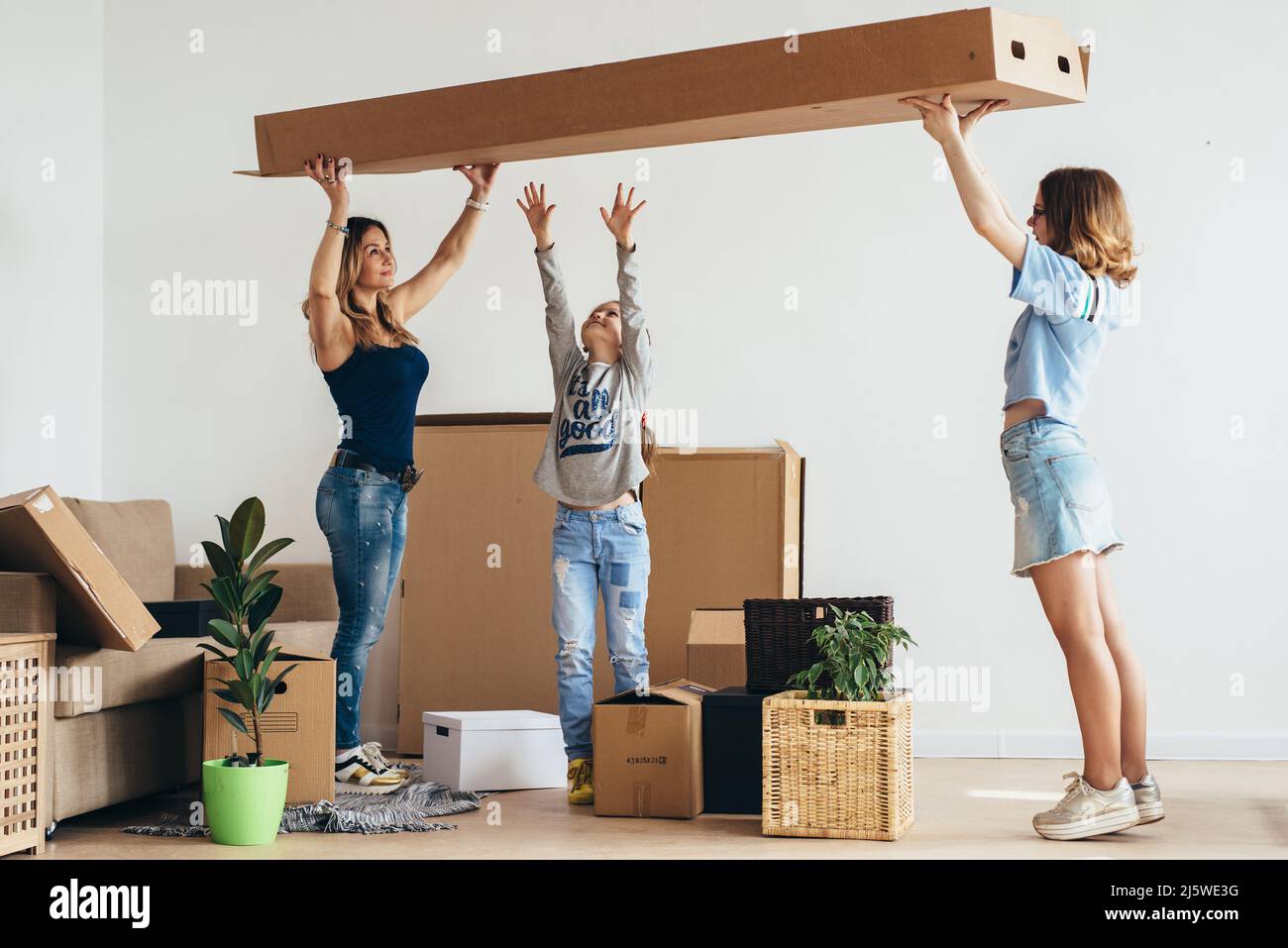 Family with cardboard boxes. Moving into new home Stock Photo - Alamy
