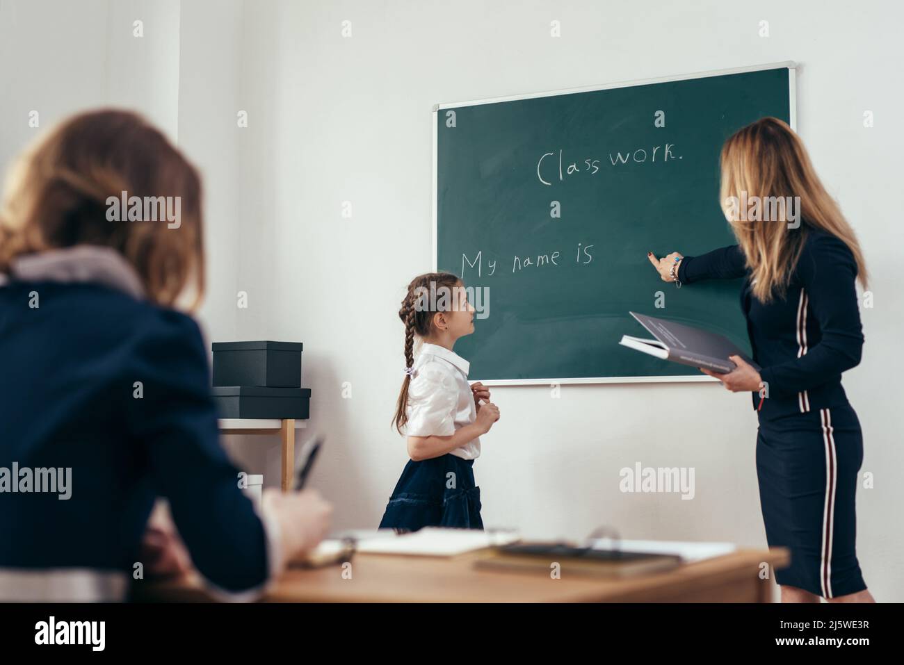 School lesson Teacher and pupil write on a blackboard Stock Photo - Alamy