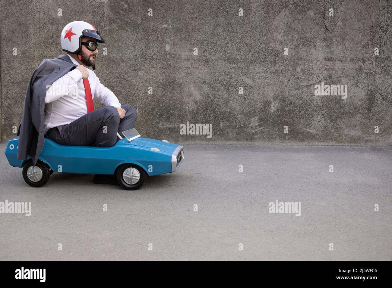 Portrait of funny businessman outdoor. Man driving retro pedal car ...