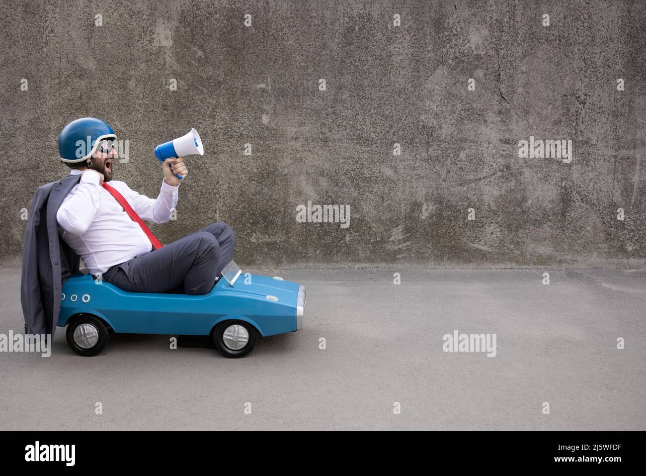 Portrait of funny businessman outdoor. Man driving retro pedal car and ...