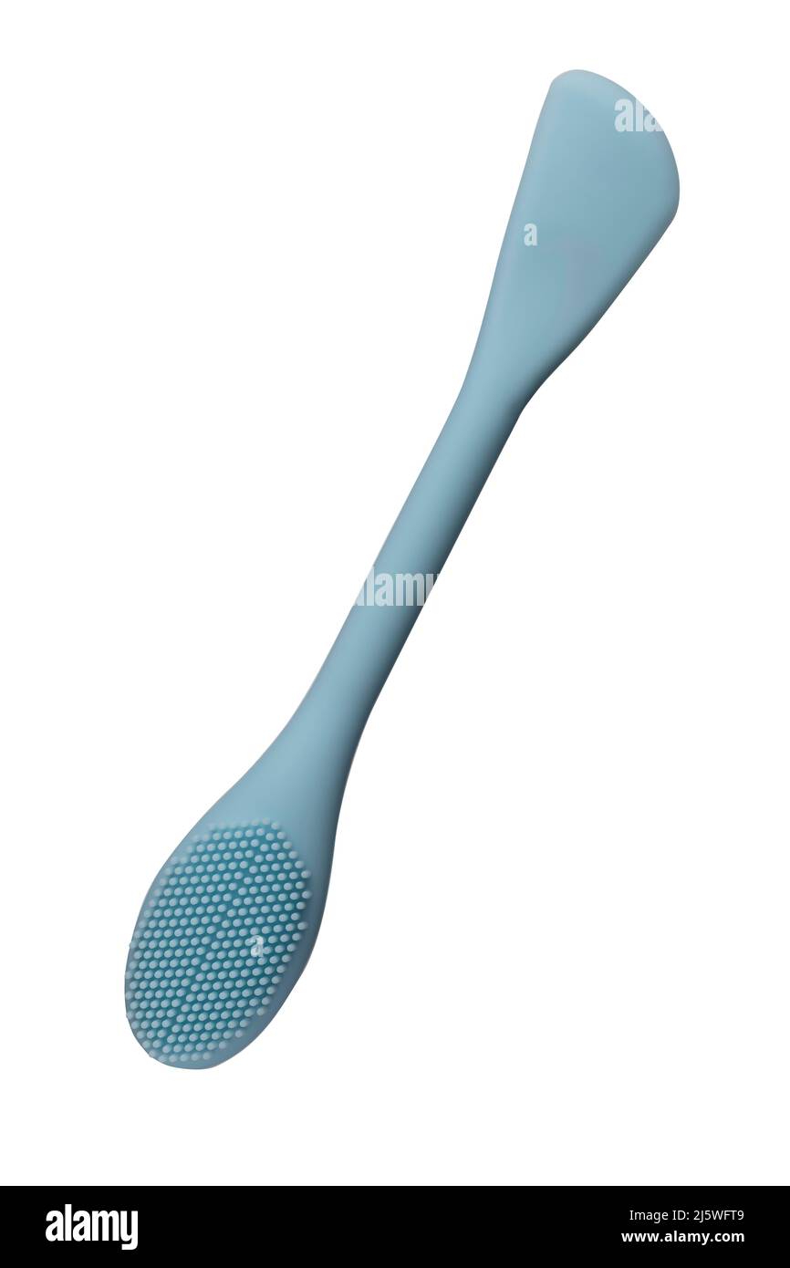 Blue silicone brush for cleansing and scrubbing the face from cosmetics. Brush for applying face mask. Turquoise color closeup. Isolated on white Stock Photo