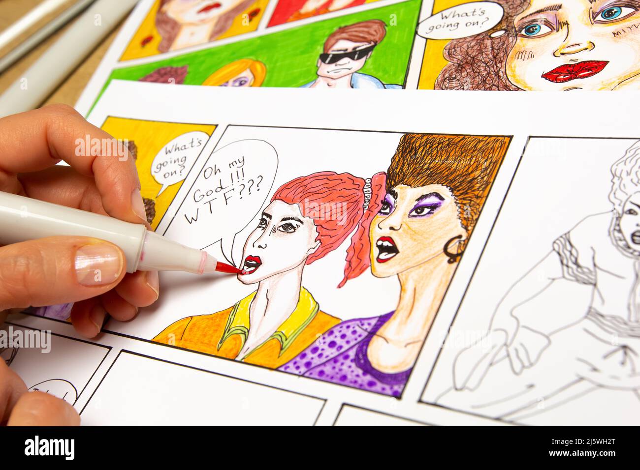 The artist designer draws sketches of comic book characters on paper. The animator creates a storyboard on paper. Stock Photo