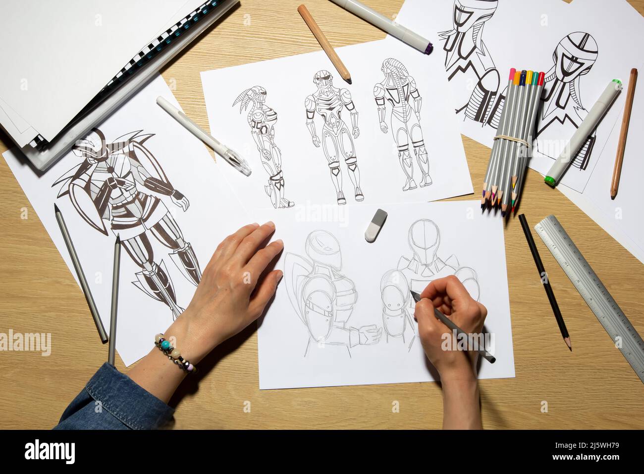 Concept art. The artist draws sketches of cyborg robots on paper. Character design for a video game. Animation creation. Stock Photo