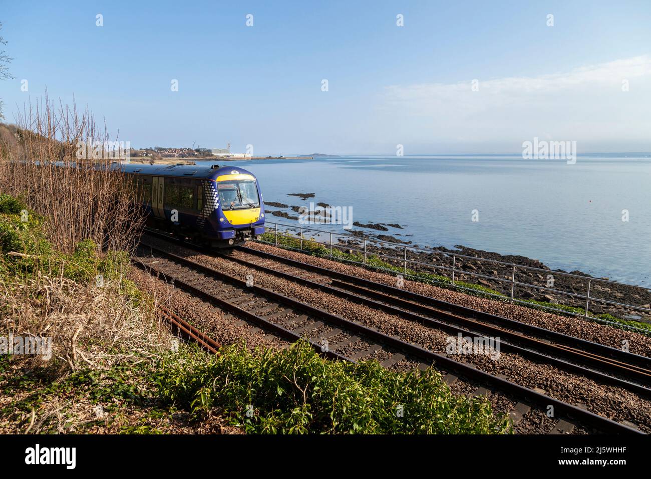 A train on the picturesque coastal line between Burntisland and Aberdour, Fife, Scotland Stock Photo