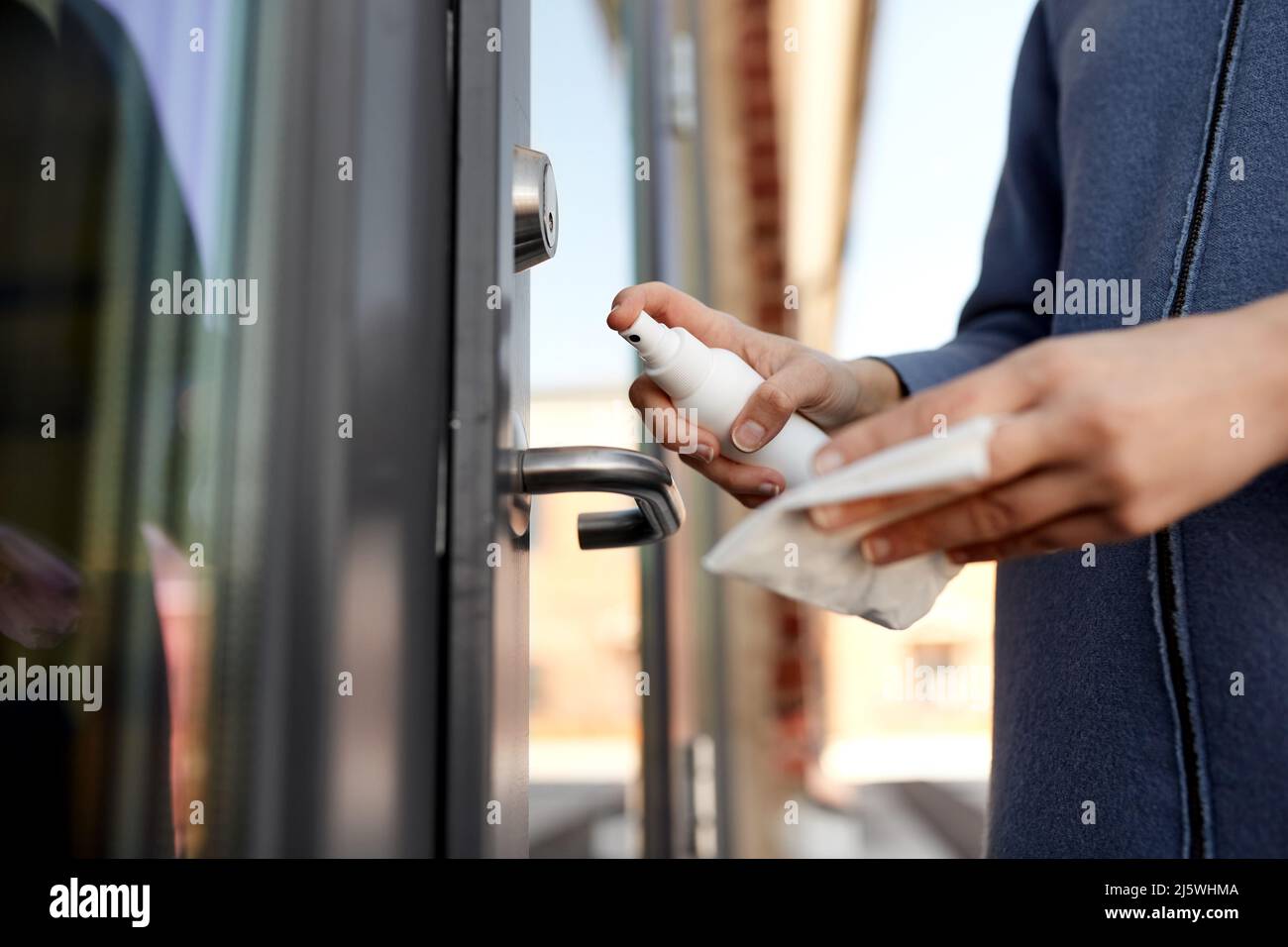 hand cleaning door handle with disinfectant spray Stock Photo Alamy