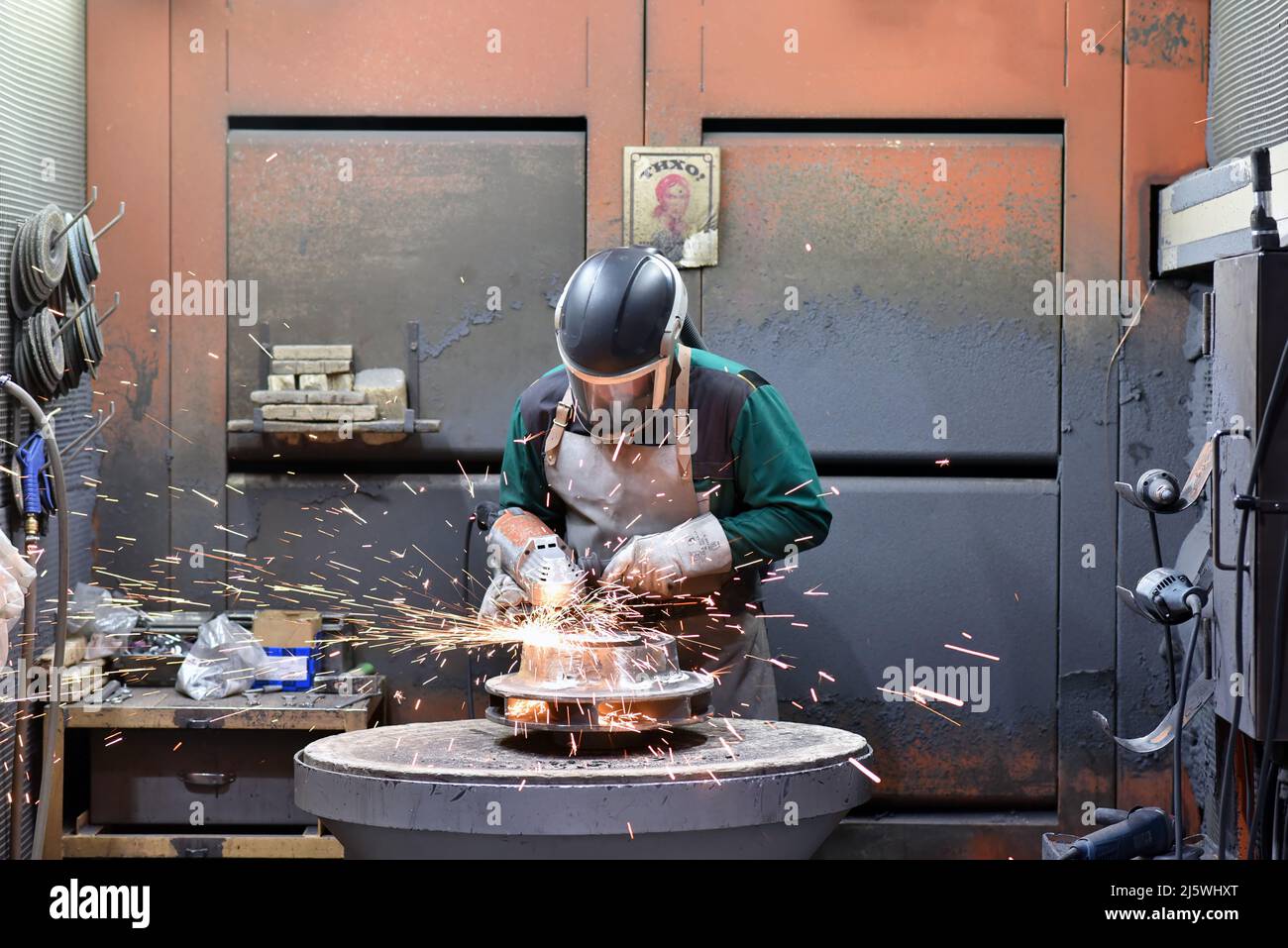 workers in safety clothing sanding a casting in an industrial company Stock Photo