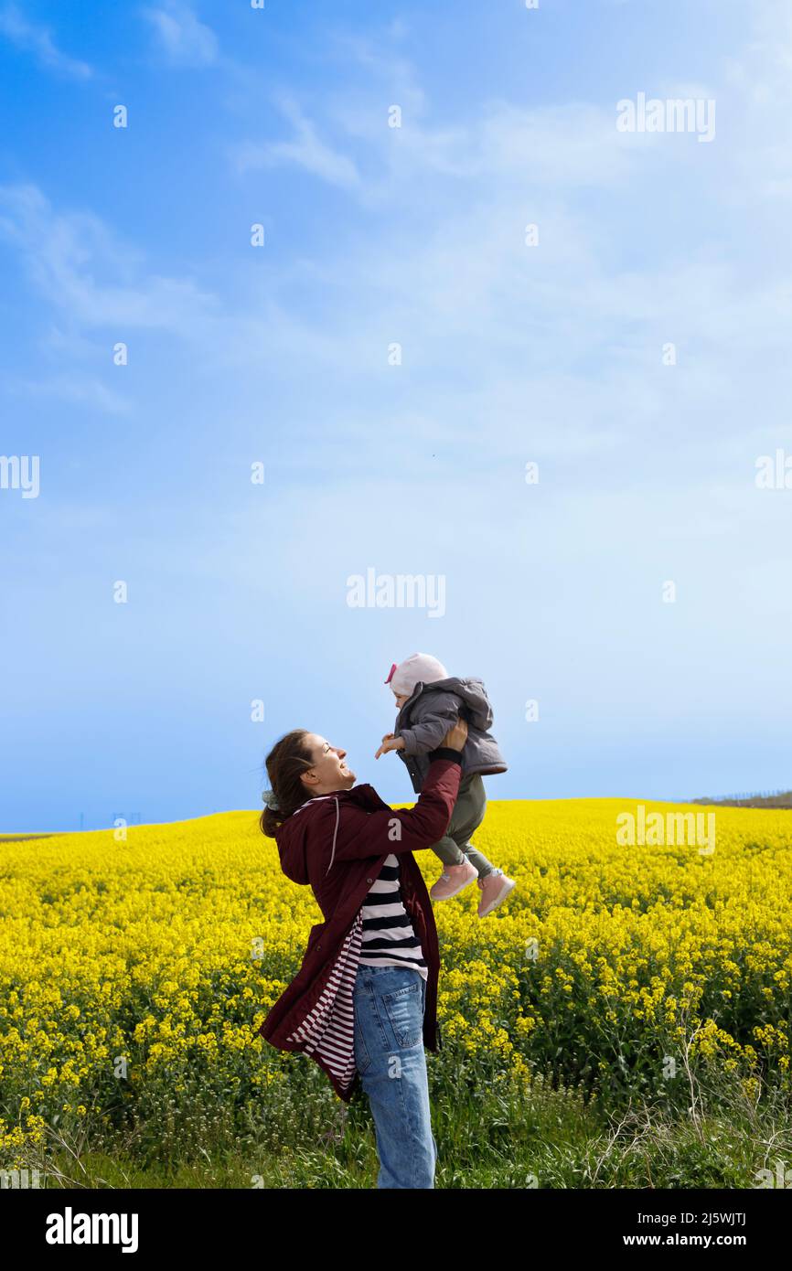 A baby and her mother enjoying a sunny day in the field Stock Photo