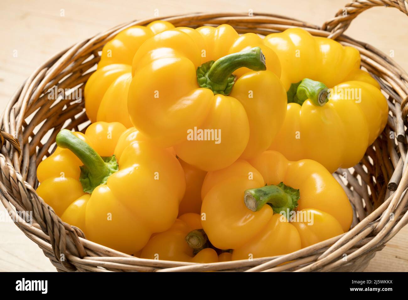 Basket with fresh picked homegrown yellow bell peppers close up Stock Photo