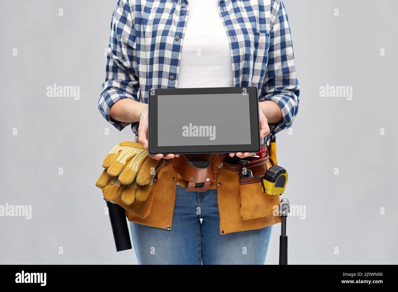 woman builder with working tools showing tablet pc Stock Photo