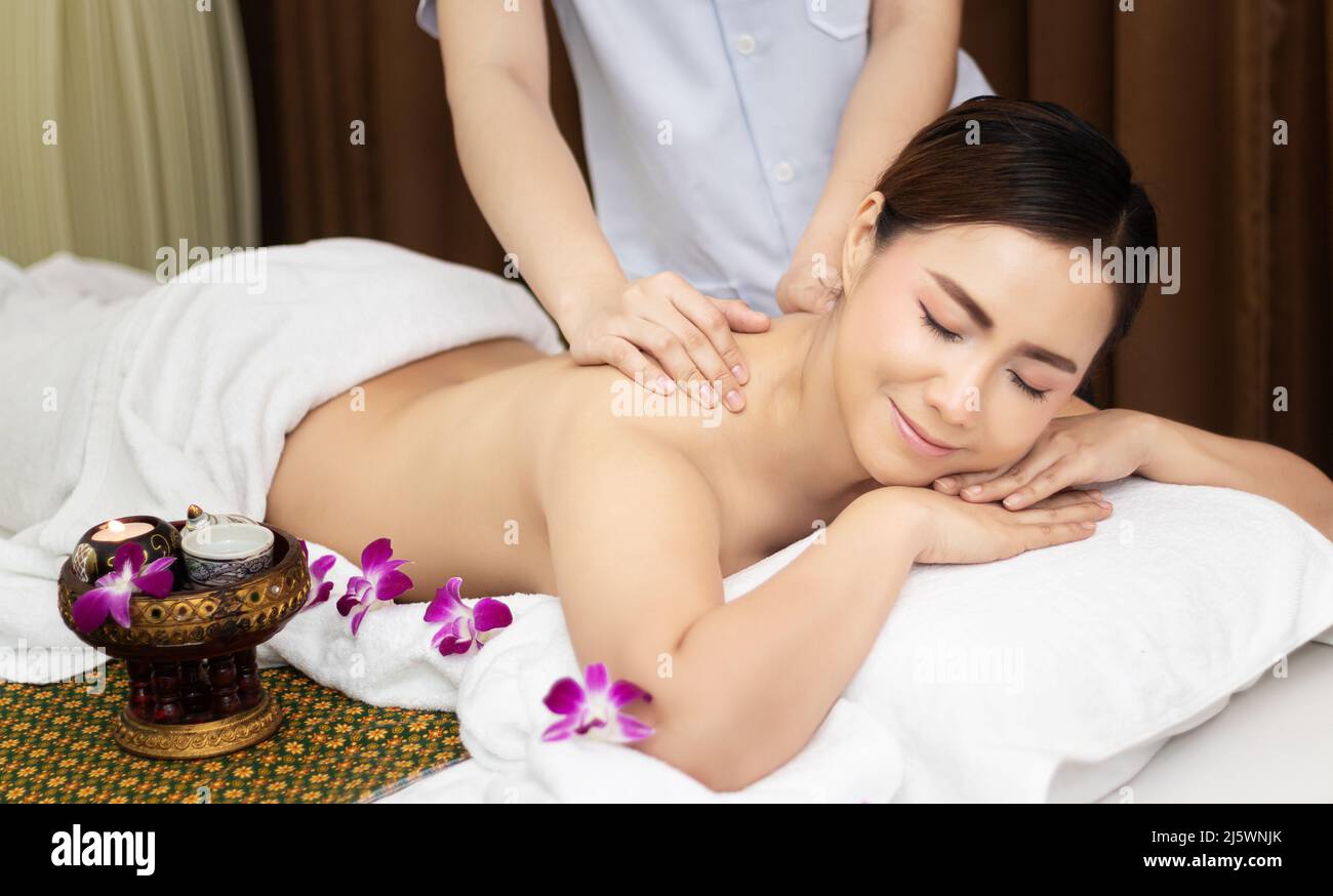 beautiful young Asian woman relaxing with hand massage on naked back body by masseur at beauty spa treatment. relaxing massage Stock Photo
