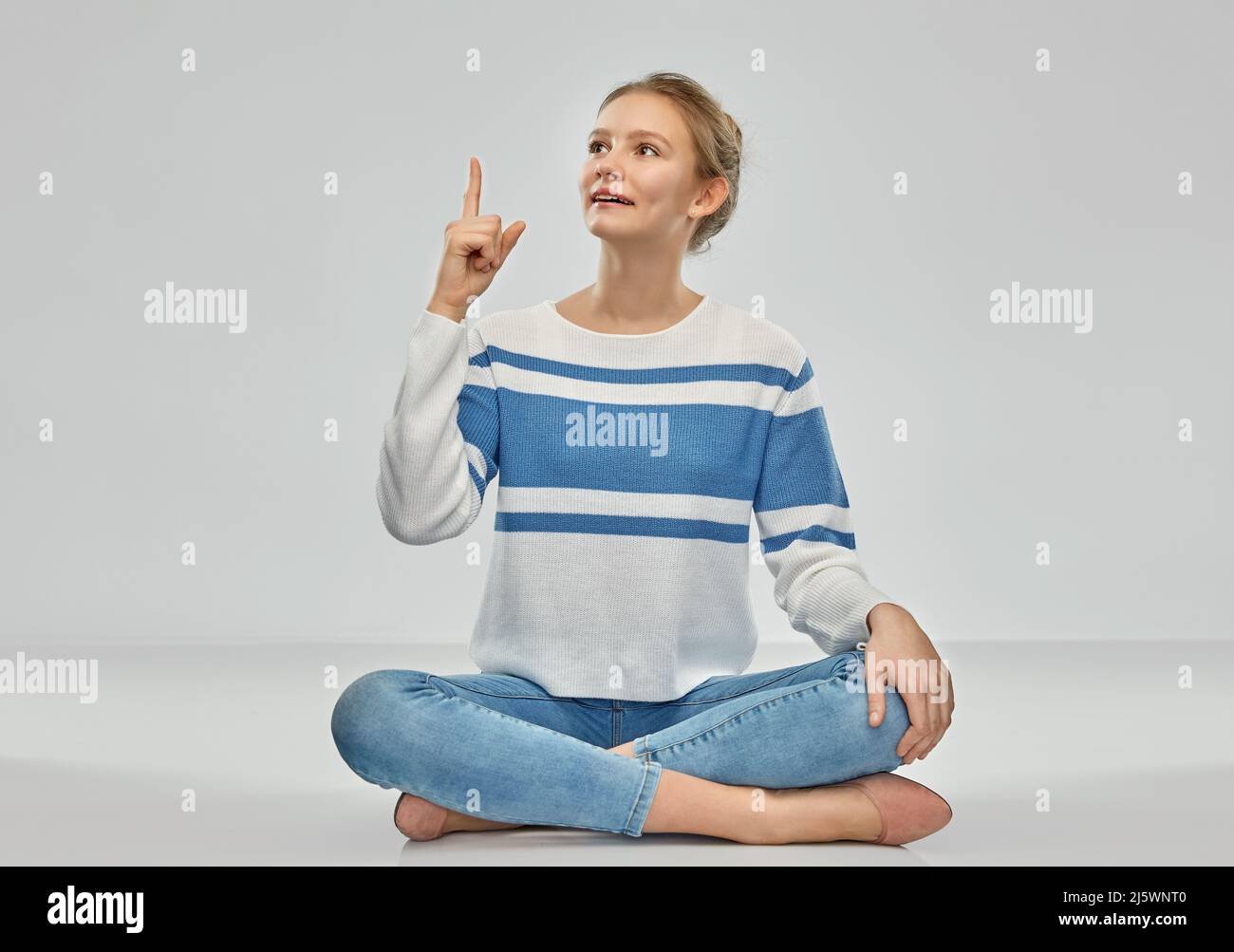 teenage girl pointing finger up sitting on floor Stock Photo - Alamy