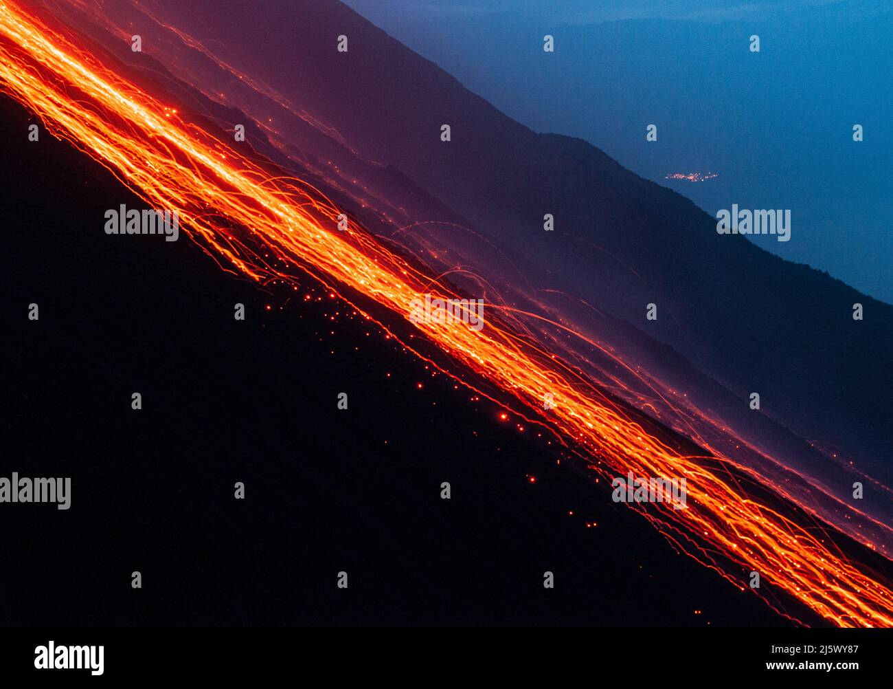 Glühende Lavabrocken kullern die Feuerrutsche des Stromboli hinab (sciara del fuoco). Langzeitbelichtung. Stock Photo