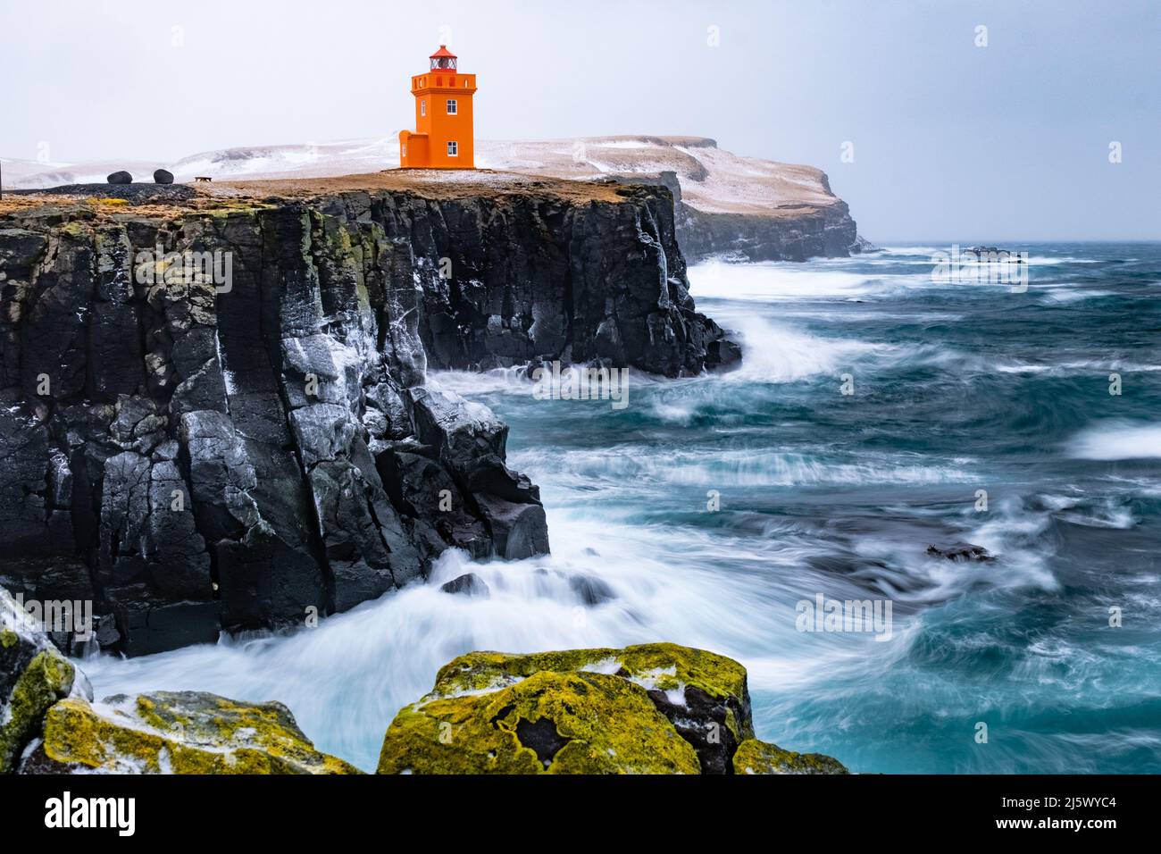 Orangener Leuchtturm an der Südspitze der Insel Grímsey, Nordisland. Langzeitaufnahme mit Graufilter. Stock Photo