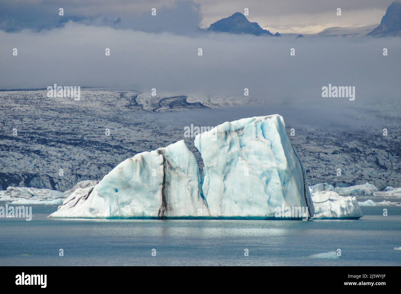 Eisberg in der Gletscherlagune Jökulsárlón, Südwest-Island. Die schwarzen Linien im Eis sind Vulkanasche subglazialer Ausbrüche der Grímsvötn. Stock Photo