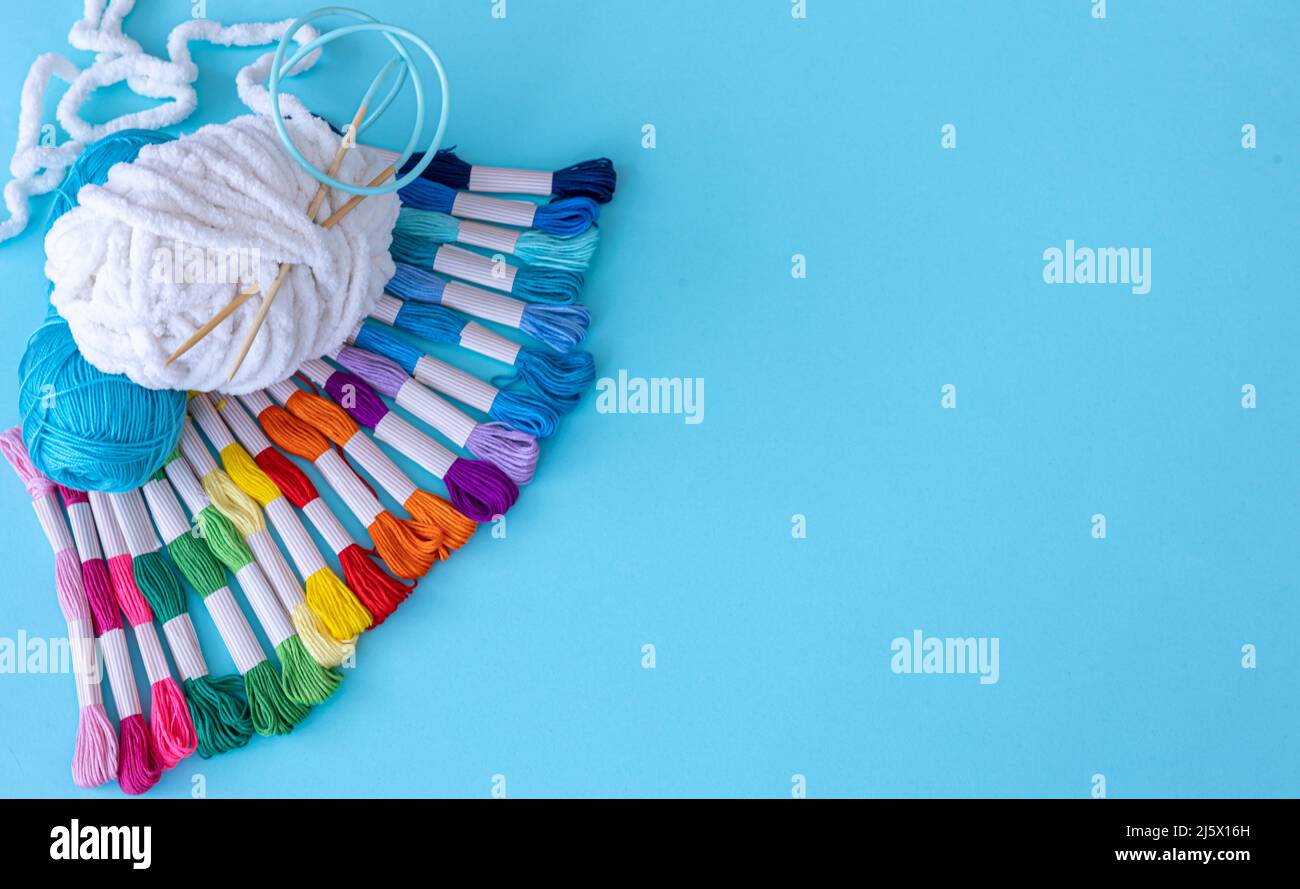 Threads of different colors on a blue background. Stock Photo