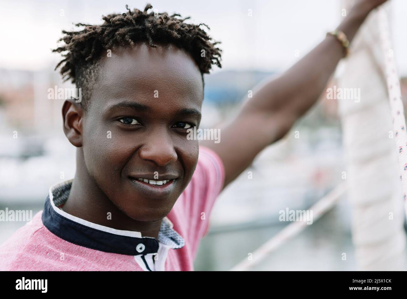 African american young man standing on boat in summer Stock Photo