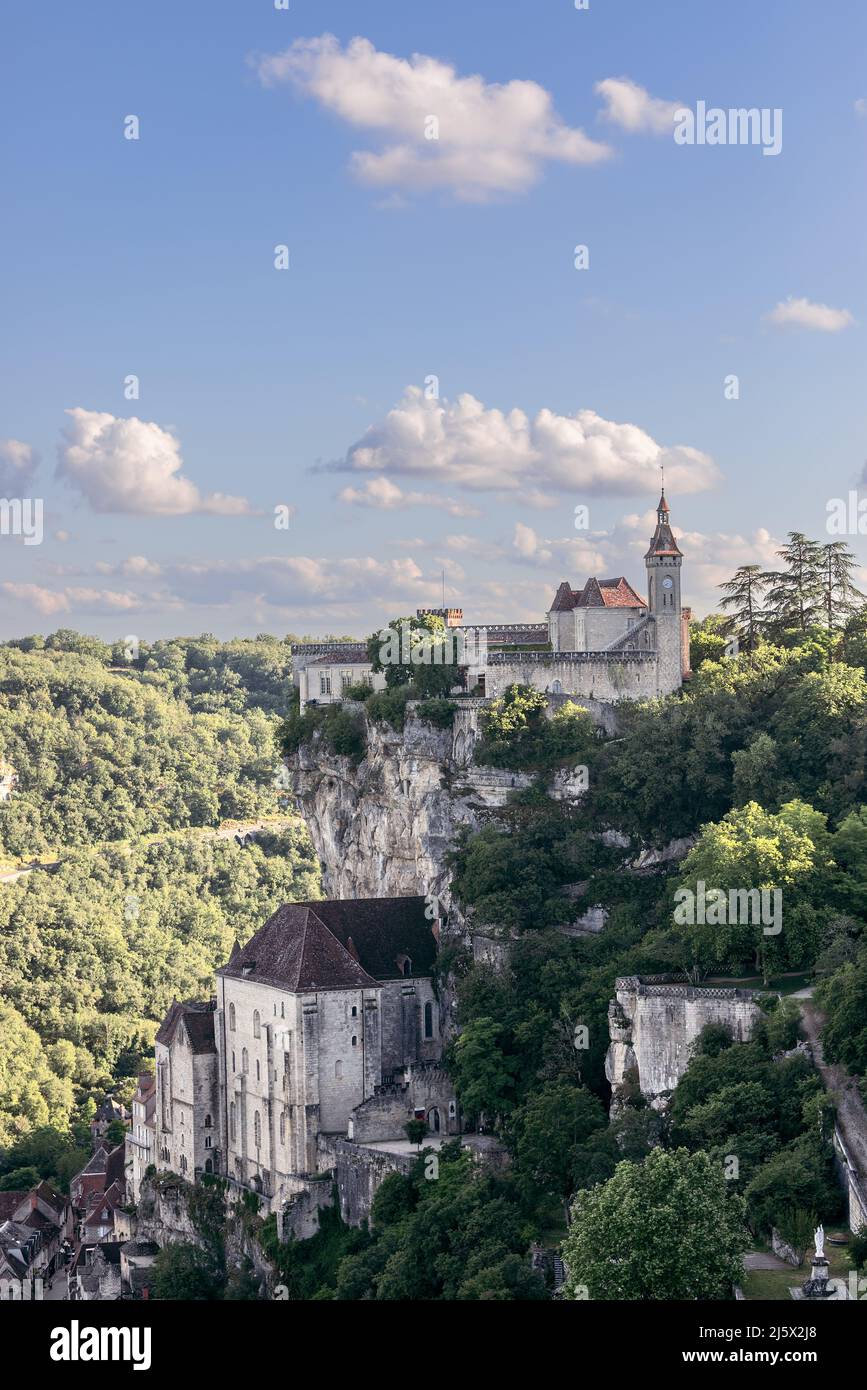 Group of massive religious buildings halfway up cliff and castle on