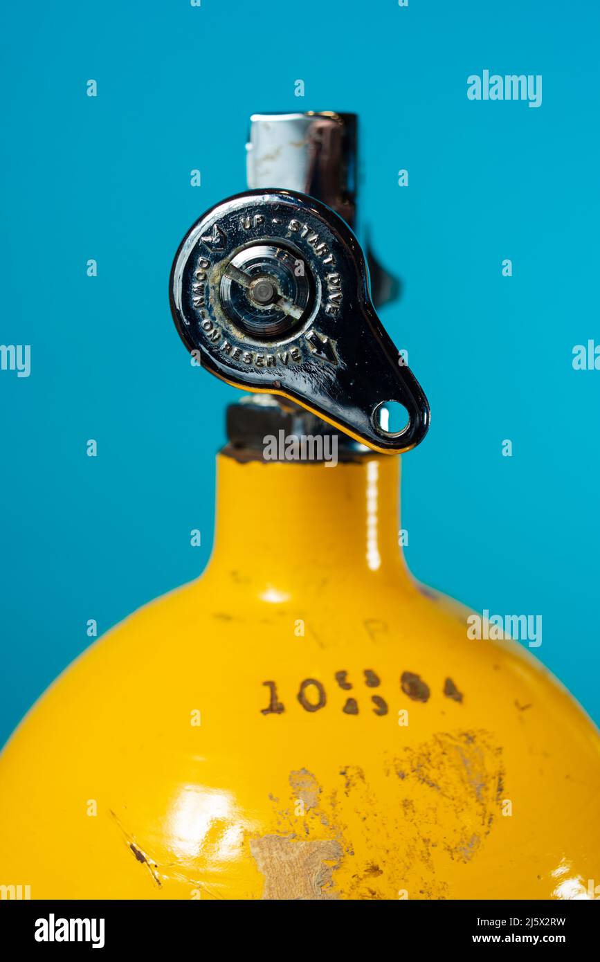 J valve in the open position on a vintage yellow steel scuba tank Stock