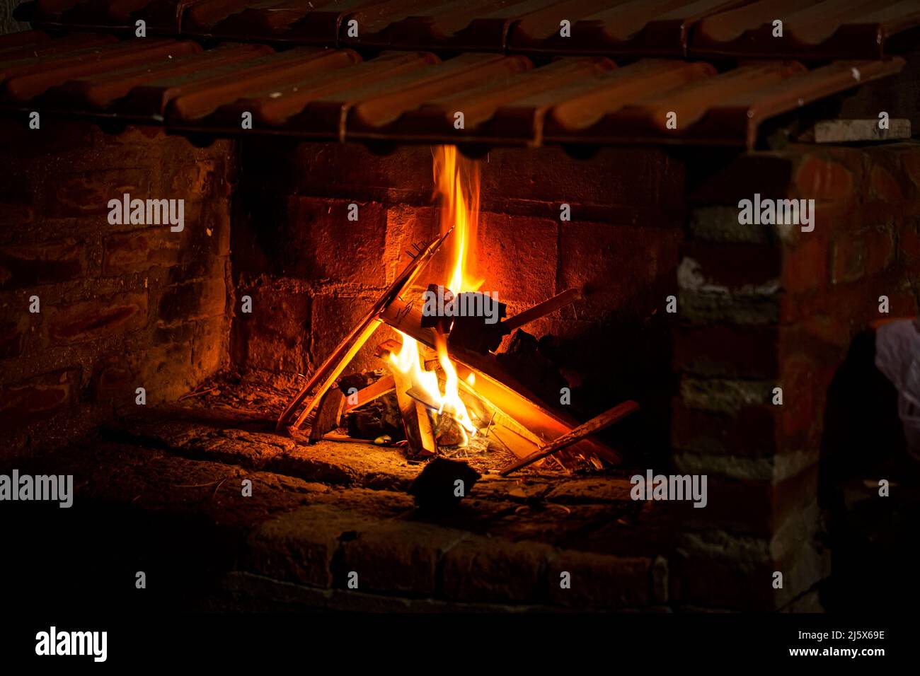 Flames in the fireplace. Burning wood. Brick fireplace Stock Photo