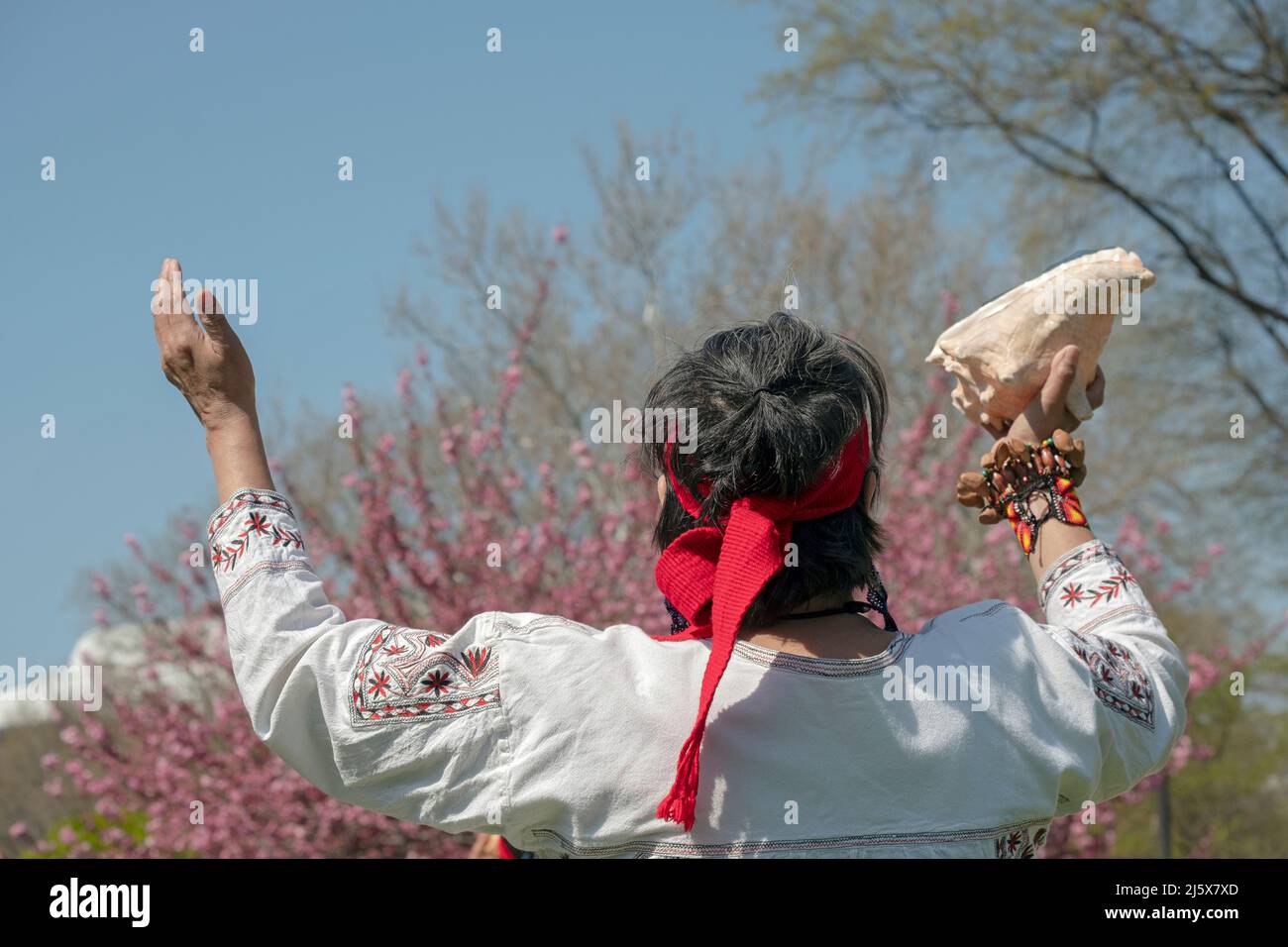 A dancer from the Calpulli Mexican Dance Group march, dances, celebrates & gives gratitude at the anniversary of Escuelita en Casa. In Queens, NYC. Stock Photo