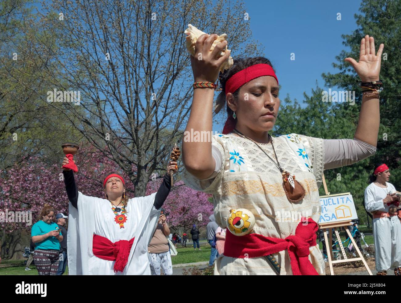 Dancers from the Calpulli Mexican Dance Group march, dance, celebrate & give gratitude at the anniversary of Escuelita en Casa. In Queens, NYC. Stock Photo