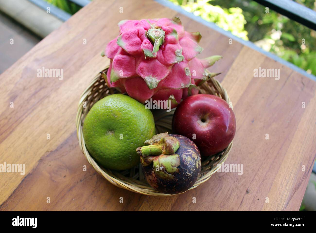 A bowl of Indonesian tropical fruits. Dragon fruit, mangosteen, apple