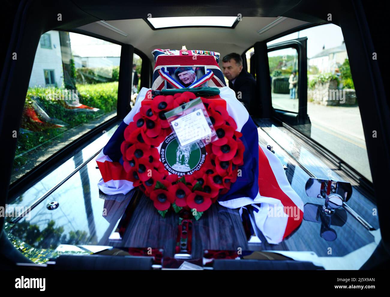 The coffin of 96-year-old World War II serviceman and Royal British Legion fundraiser Harry Billinge is put into a hearse after being carried out of St Paul's Church in Charlestown, Cornwall. Harry was just 18 when he was one of the first British soldiers to land on Gold Beach during the Battle for Normandy and was one of only four survivors from his unit. Picture date: Tuesday April 26, 2022. Stock Photo