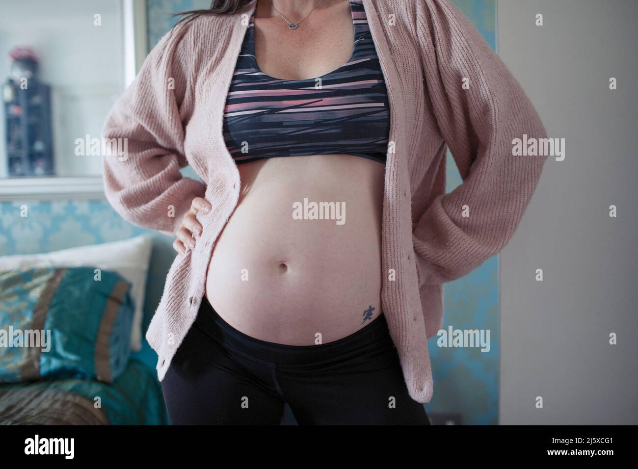 Pregnant woman in sports bra Stock Photo