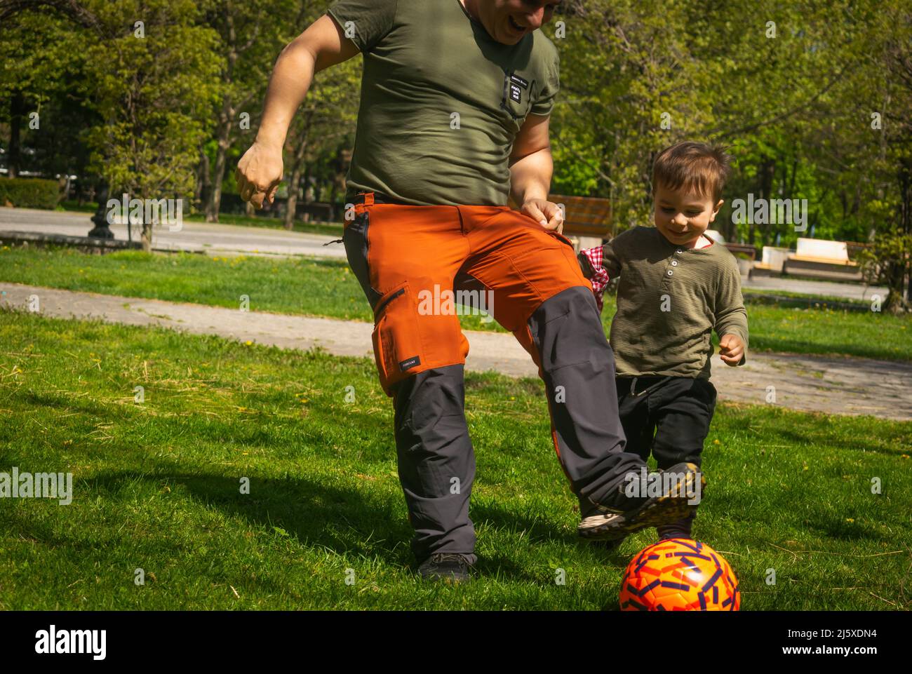 Father and son playing football in park outdoor family activities football fans supporters warming for Qatar World Cup 2022 father and son playing ama Stock Photo