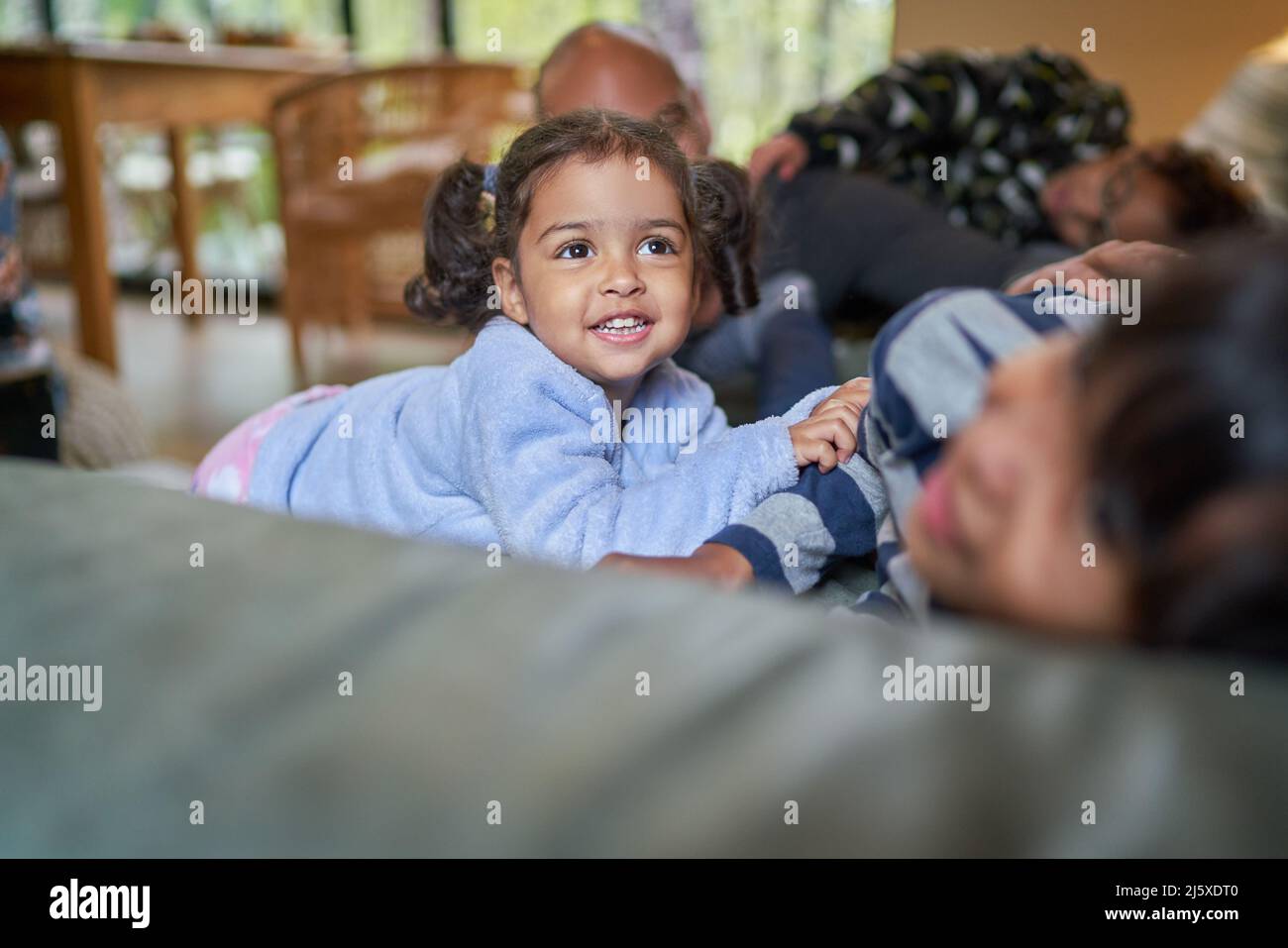 Happy toddler girl with family on sofa Stock Photo