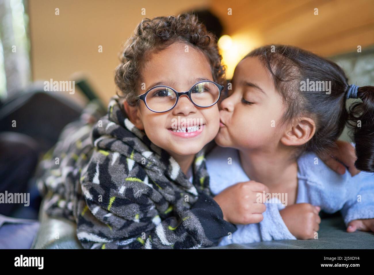 Portrait cute sister kissing brother in cheek Stock Photo