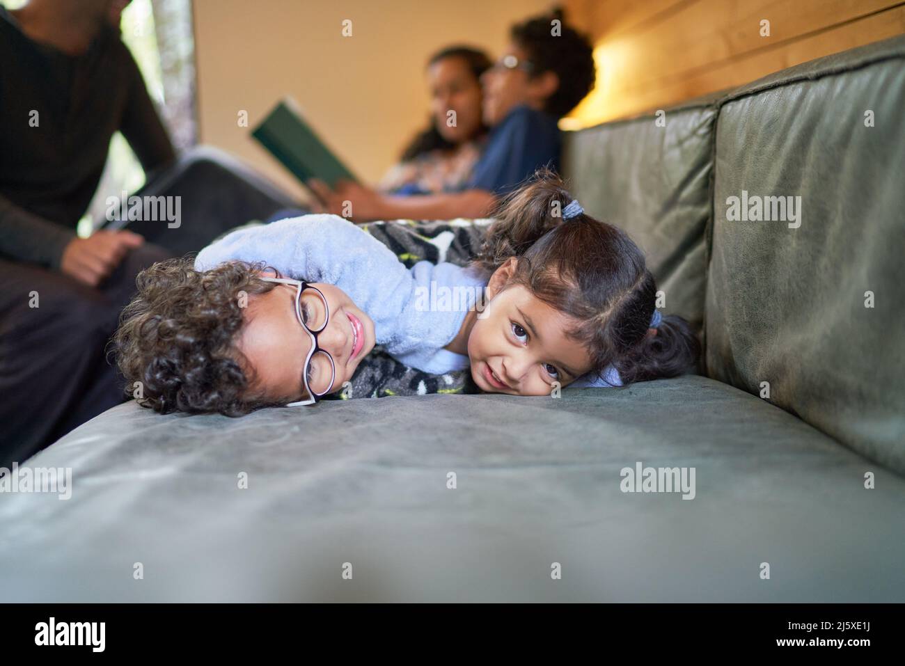 Portrait cute brother and sister laying on living room sofa Stock Photo
