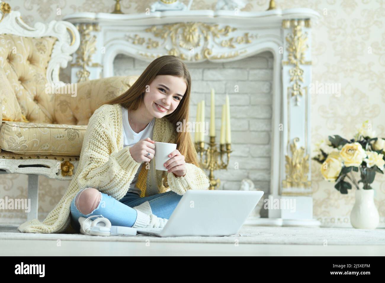 Beautiful teen girl sitting on floor near vintage armchair Stock Photo ...