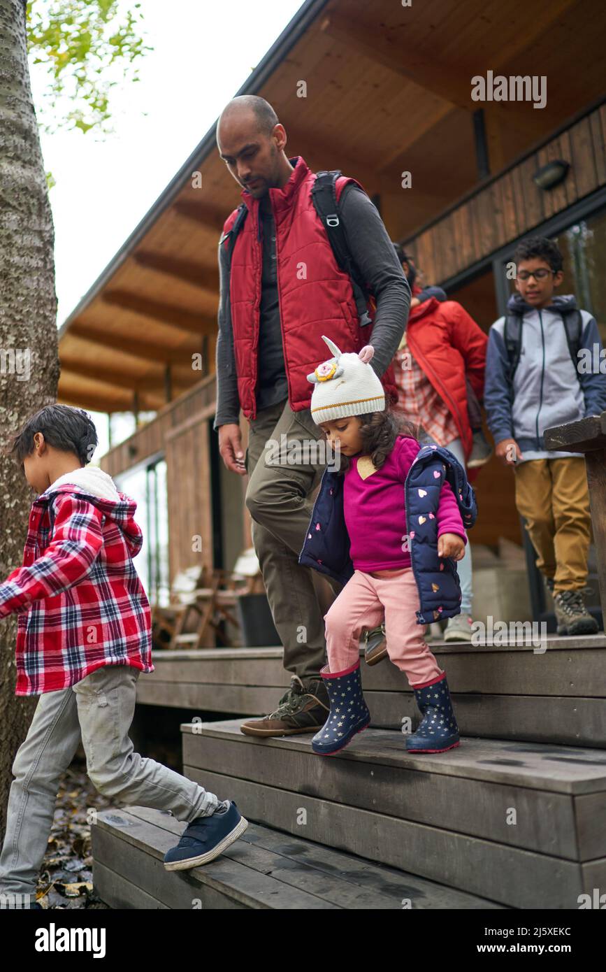 Family leaving cabin for hike Stock Photo