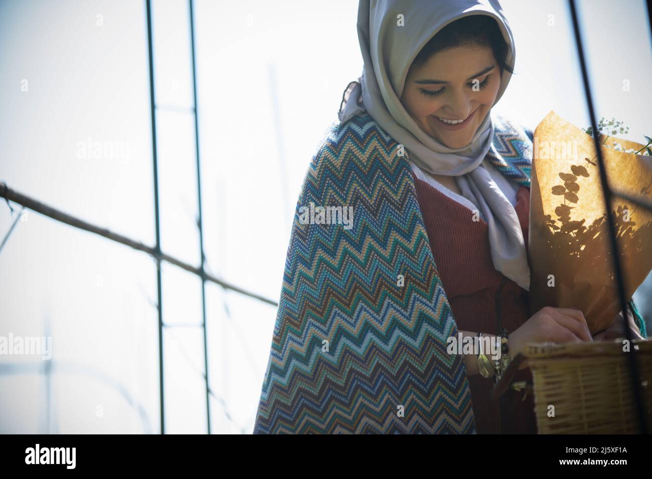 Happy young Muslim woman in headscarf looking down Stock Photo