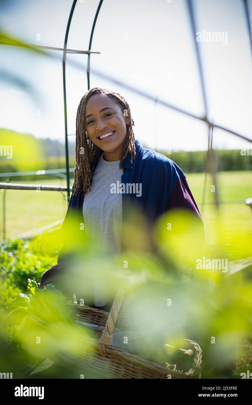 Portrait happy young woman gardening in sunny garden Stock Photo - Alamy
