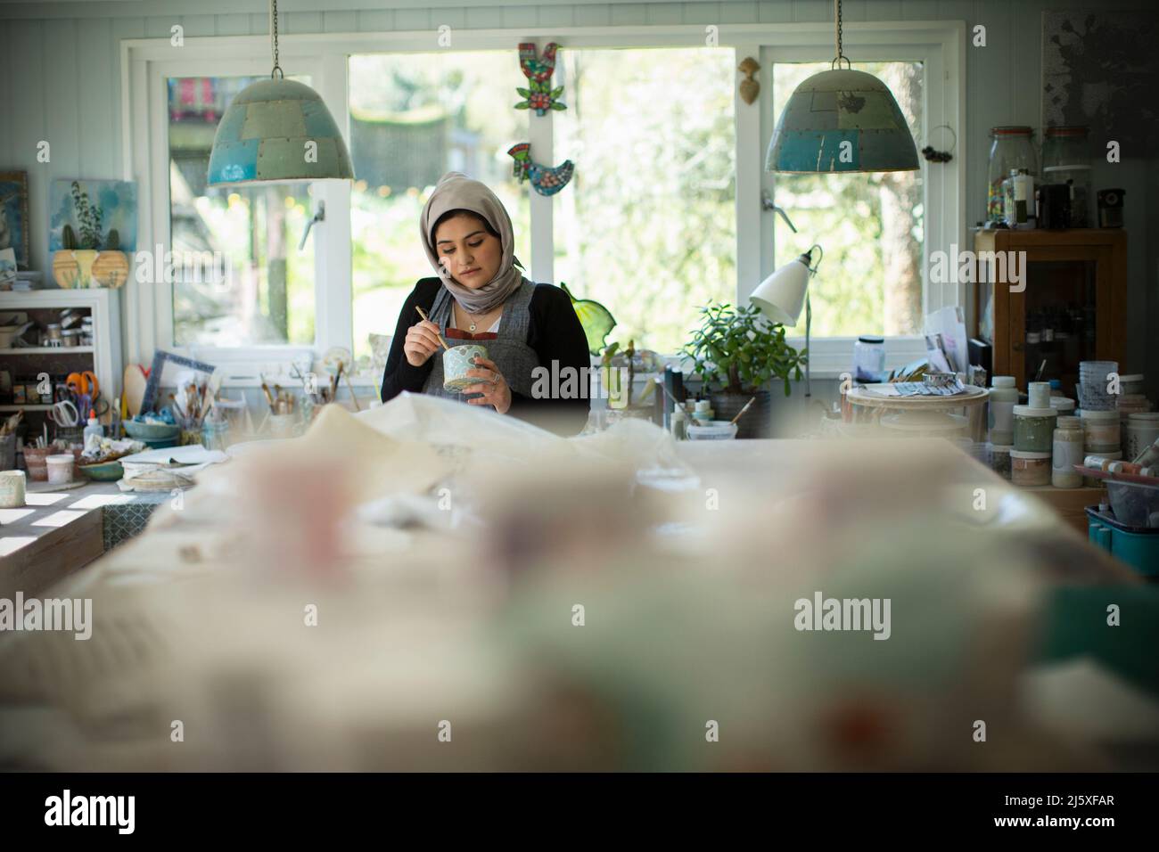 Young female Muslim artist working in art studio Stock Photo