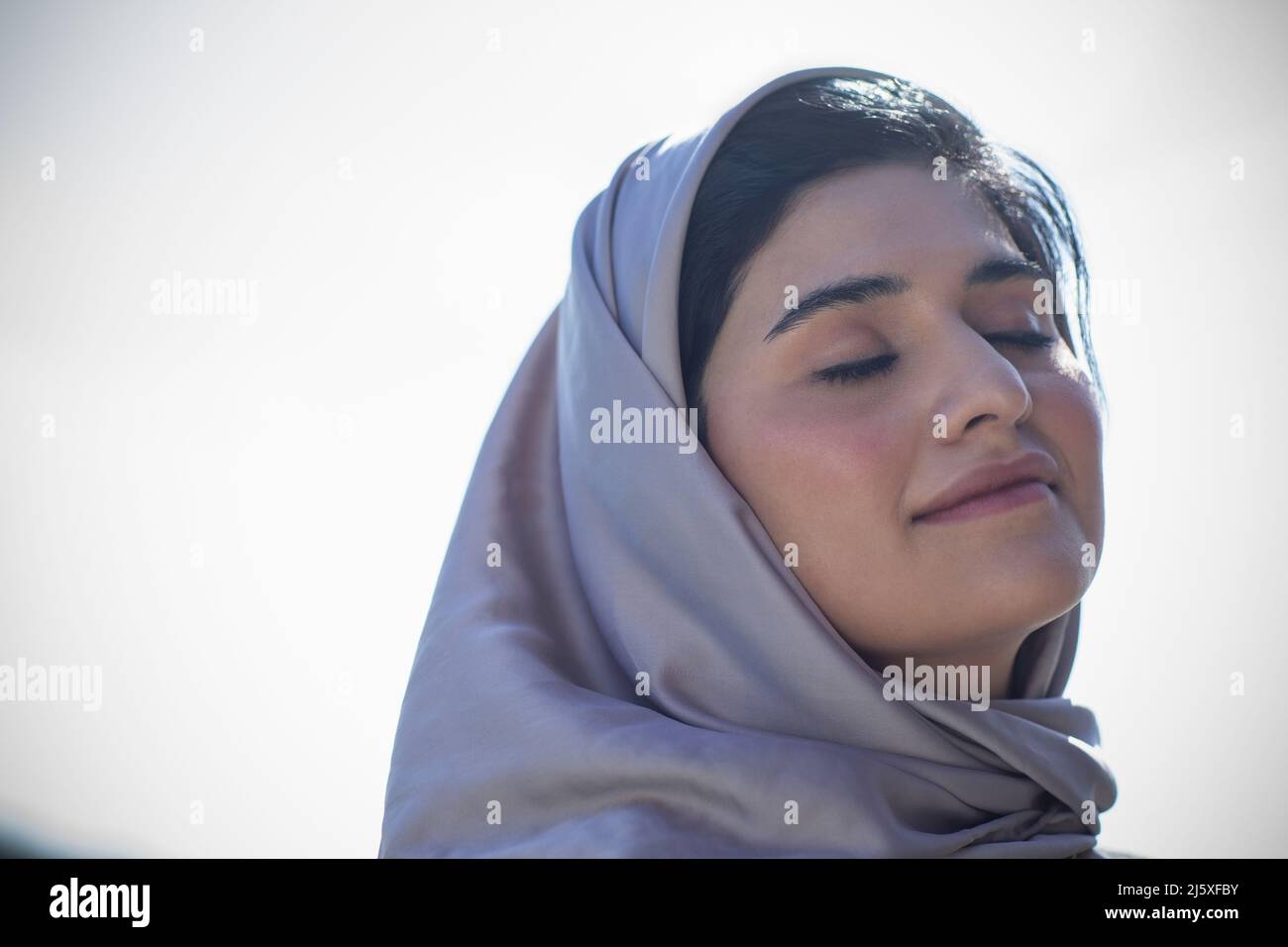 Beautiful serene young Muslim woman in hijab Stock Photo