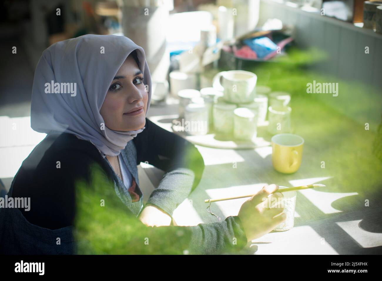Portrait confident young female Muslim artist in art studio Stock Photo