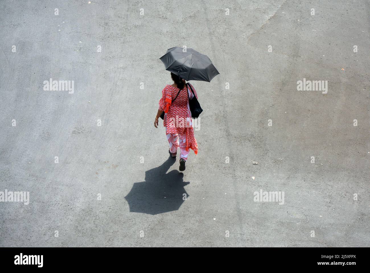 Kolkata, India. 26th Apr, 2022. A woman came outside holding an umbrella in a hot summer day.Today's temperature in Kolkata is around 40°c. The Met office declared a heatwave alert for most districts in South Bengal till 28th April.But it will continue to be warm and uncomfortable with no chance of rain, according to the Regional Meteorological Centre (RMC) till April 28. (Photo by Rahul Sadhukhan/Pacific Press) Credit: Pacific Press Media Production Corp./Alamy Live News Stock Photo