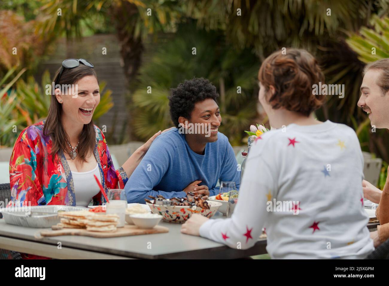 Happy friends enjoying lunch at patio table Stock Photo Alamy