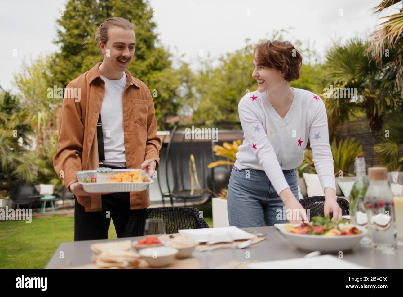 Young couple setting patio table for lunch Stock Photo Alamy